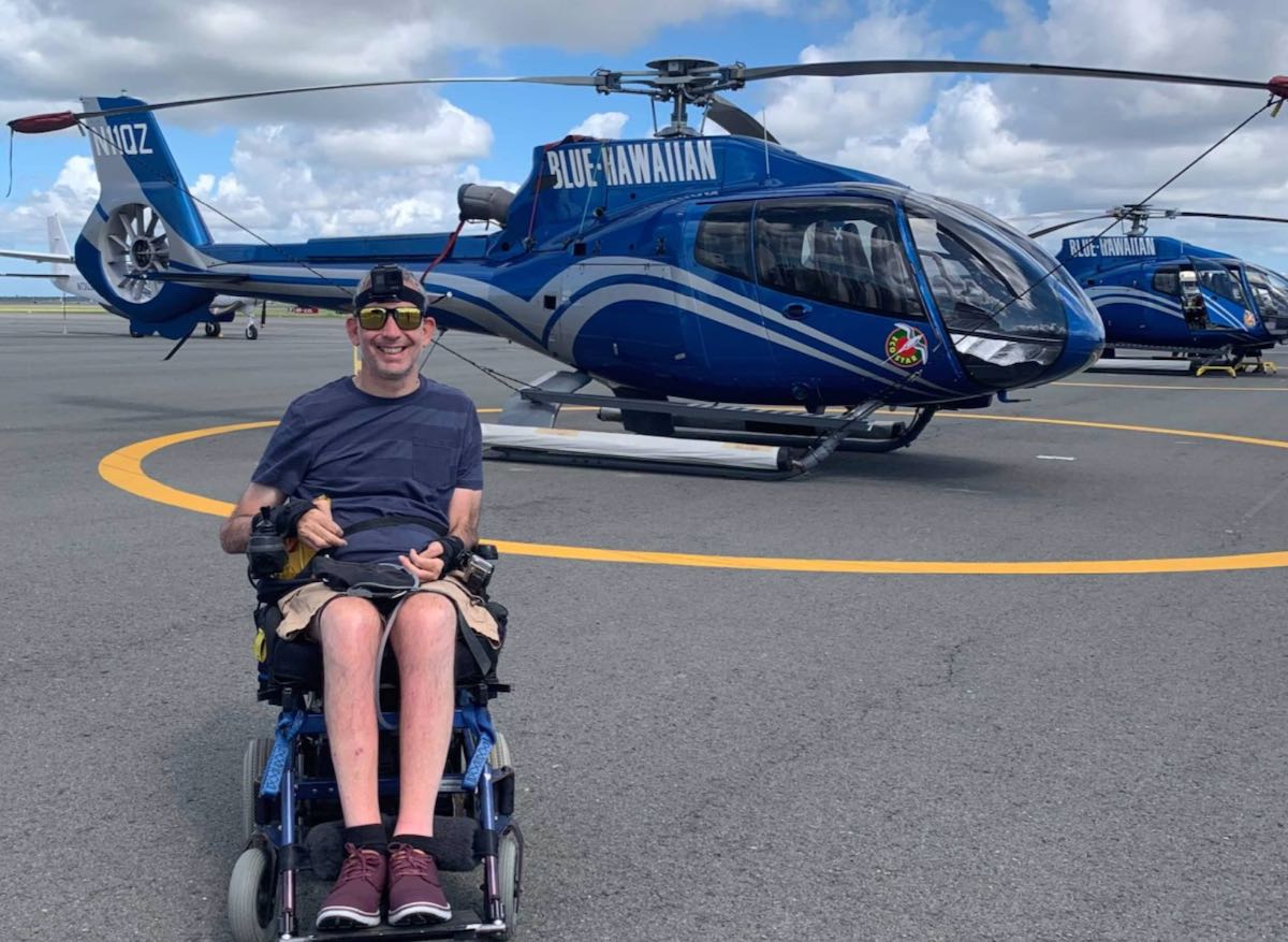 Photo of Lindsay alongside helicopter